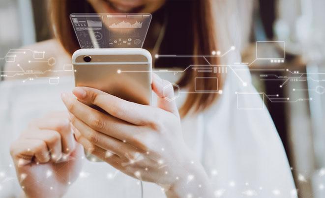 A woman uses a smartphone with digital data graphics and futuristic interface overlays glowing around the device.